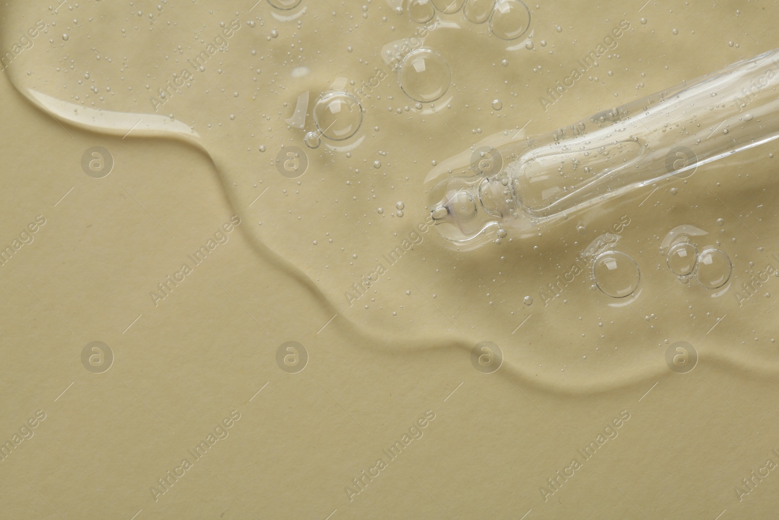 Photo of Pipette with cosmetic serum on beige background, top view. Space for text