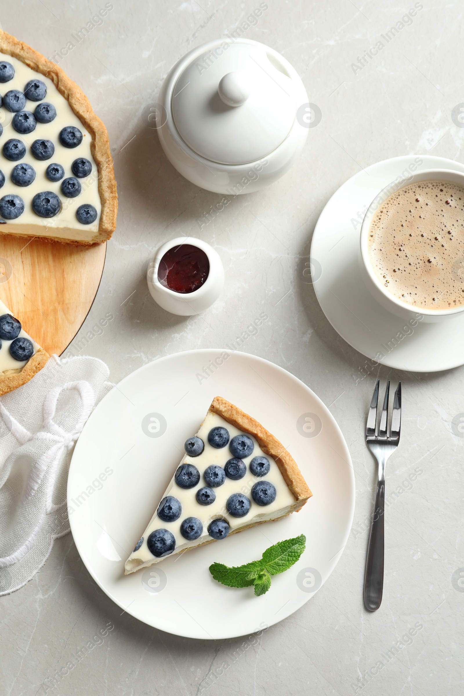 Photo of Flat lay composition with piece of tasty blueberry cake on gray table