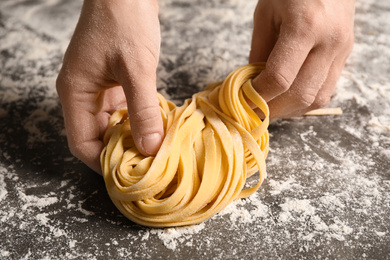 Photo of Woman holding pasta at table, closeup view