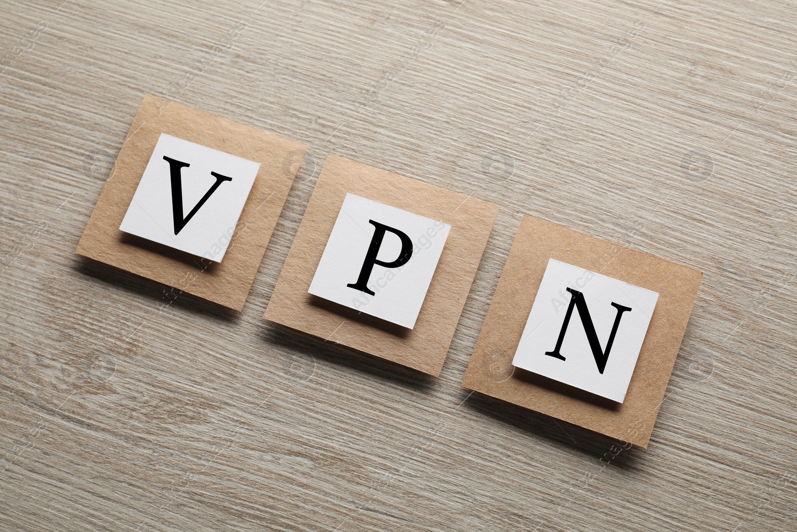 Photo of Paper notes with acronym VPN on wooden table