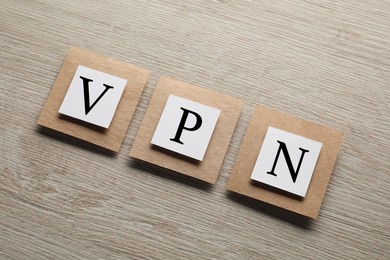 Photo of Paper notes with acronym VPN on wooden table