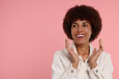 Portrait of happy young woman on pink background. Space for text