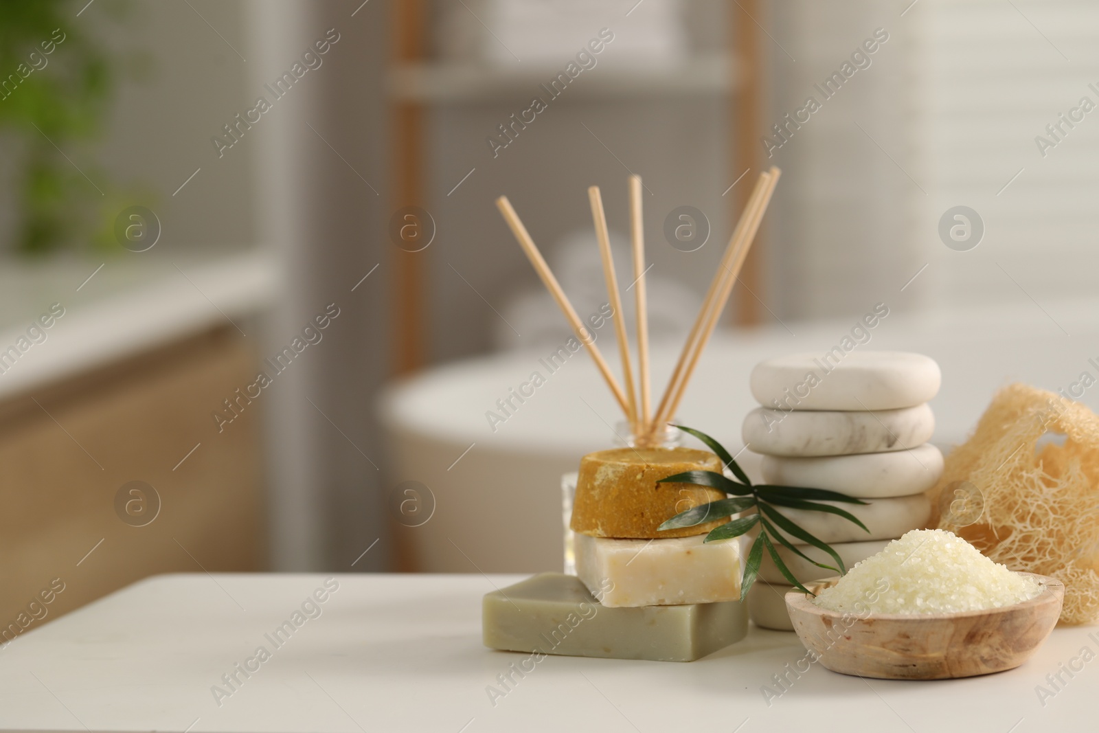 Photo of Composition with different spa products and palm leaves on white table in bathroom, space for text