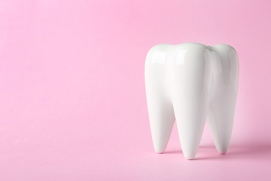 Photo of Ceramic model of tooth on color background. Space for text