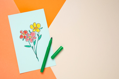 Photo of Top view of greeting card with drawn flowers and felt tip pen on color background, space for text. Happy mother's day