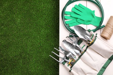 Photo of Different gardening tools on green grass, flat lay. Space for text