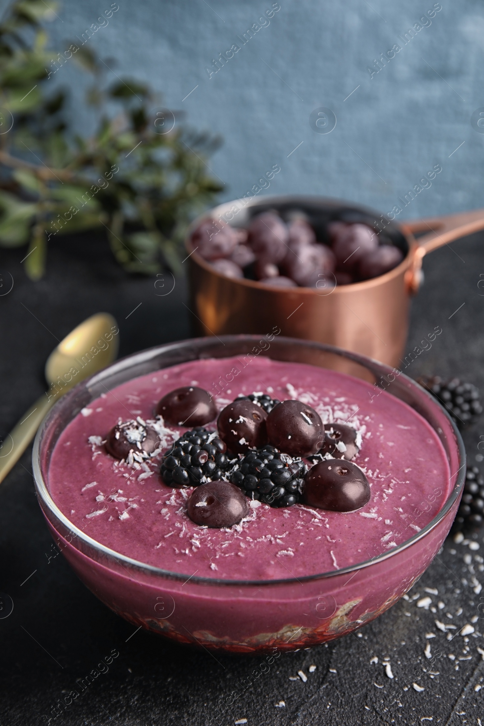 Photo of Bowl of tasty acai smoothie on dark table