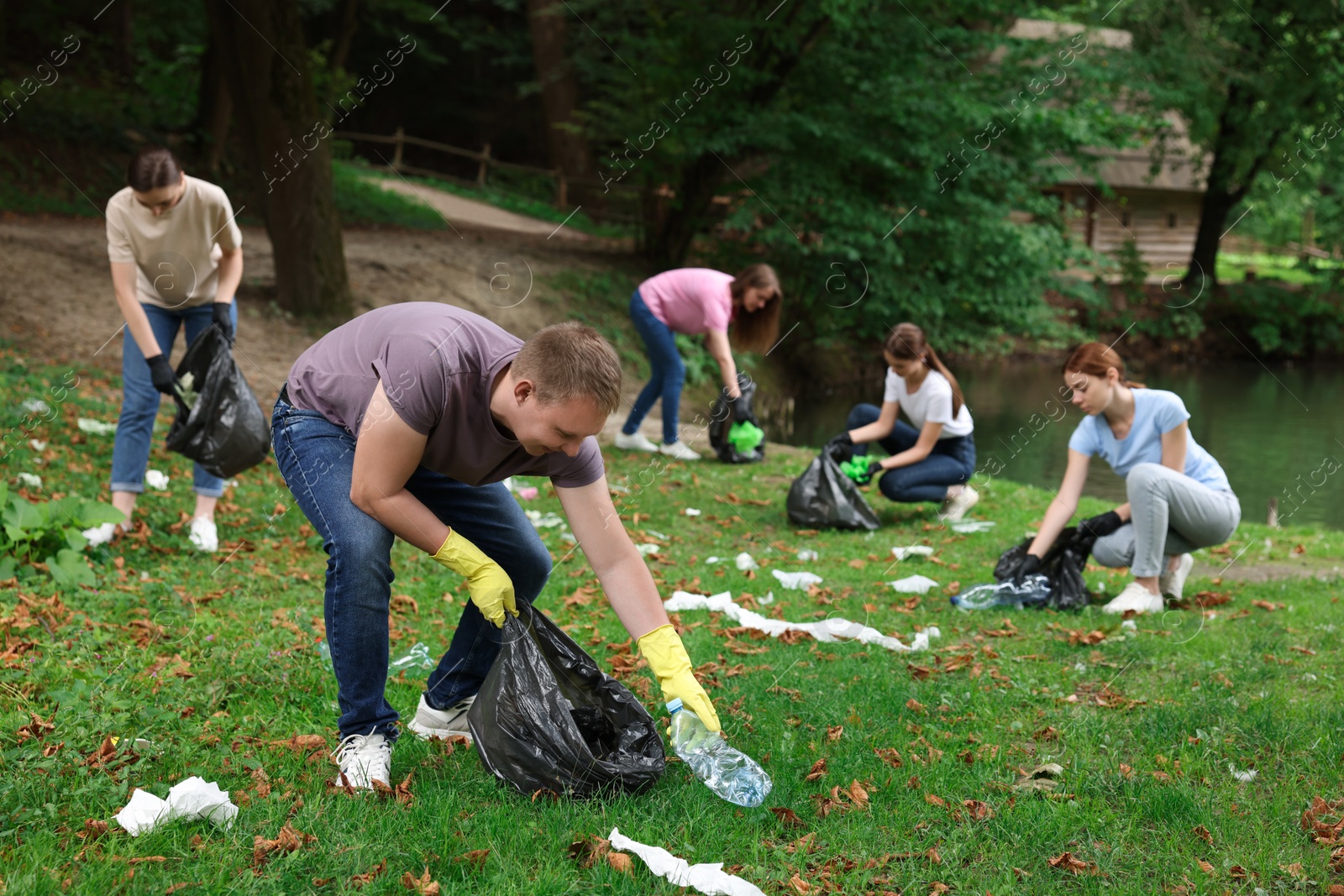 Photo of Group of people with plastic bags collecting garbage in park