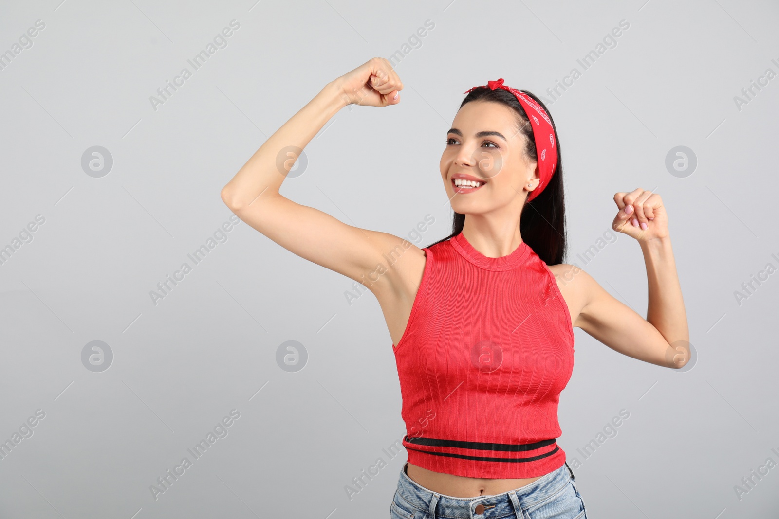 Photo of Strong woman as symbol of girl power on light grey background. 8 March concept