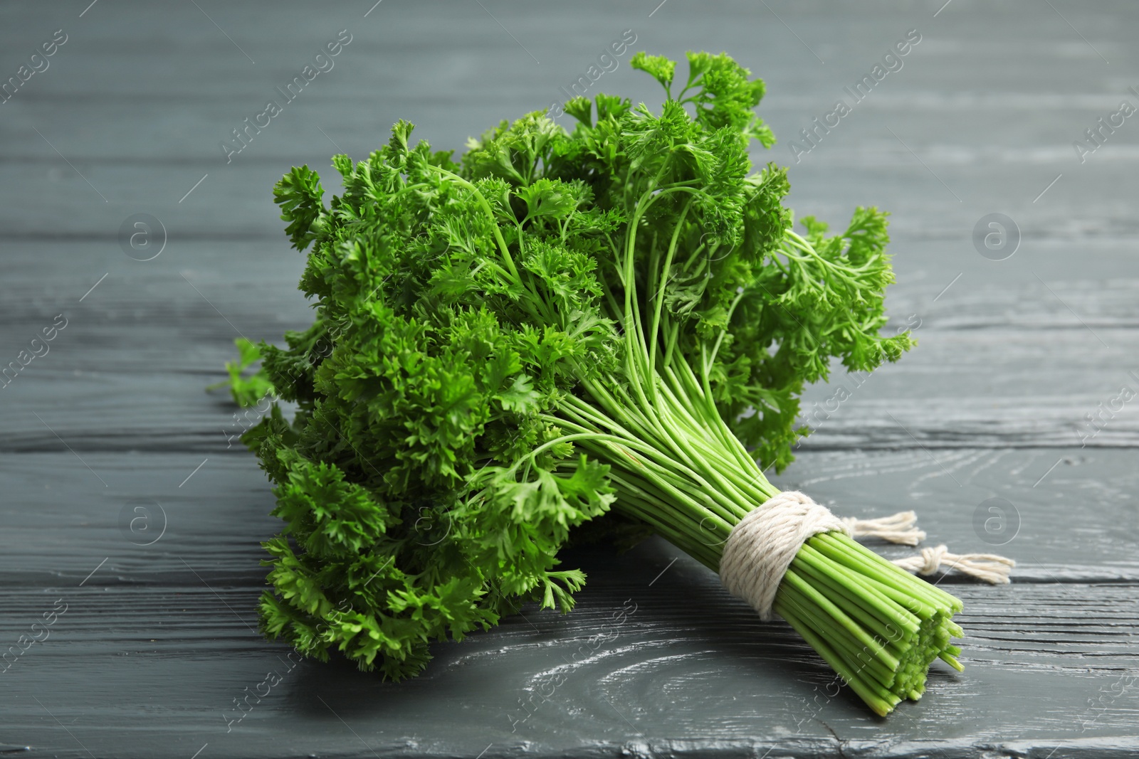 Photo of Bunch of fresh green parsley on wooden background