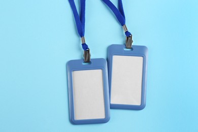 Blank badges on light blue background, flat lay. Mockup for design