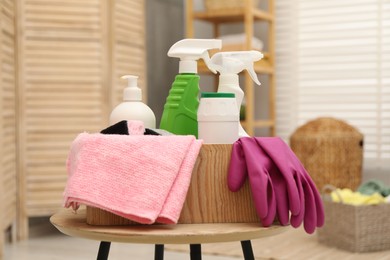 Photo of Different cleaning products in wooden box on table indoors
