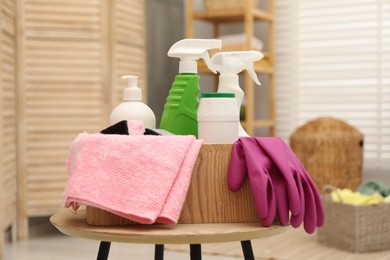 Different cleaning products in wooden box on table indoors