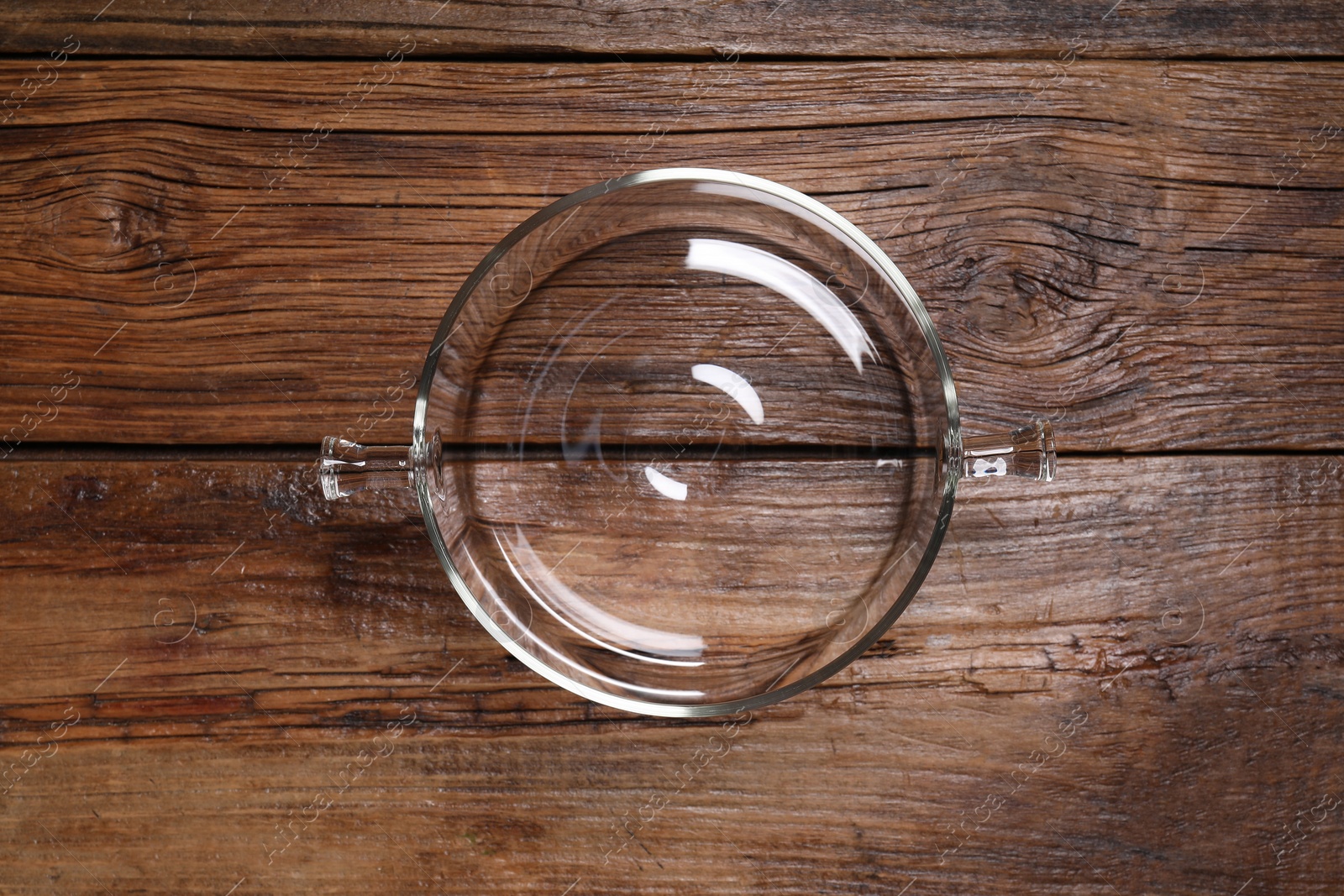 Photo of One empty glass pot on wooden table, top view