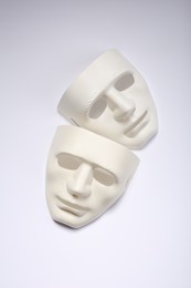Photo of Theater arts. Two masks on white background, top view