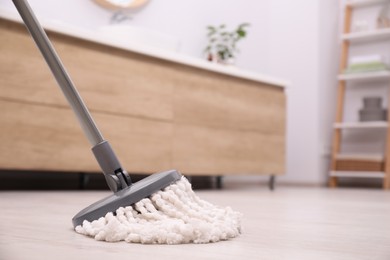 Photo of Cleaning dirty floor with mop in bathroom. Space for text