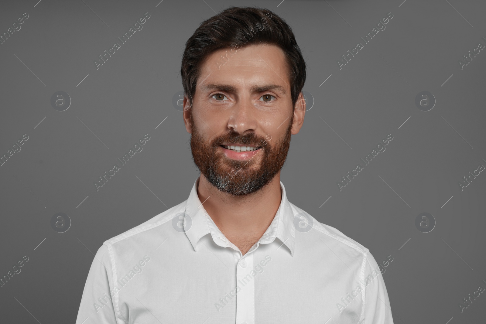 Photo of Portrait of handsome bearded man on grey background