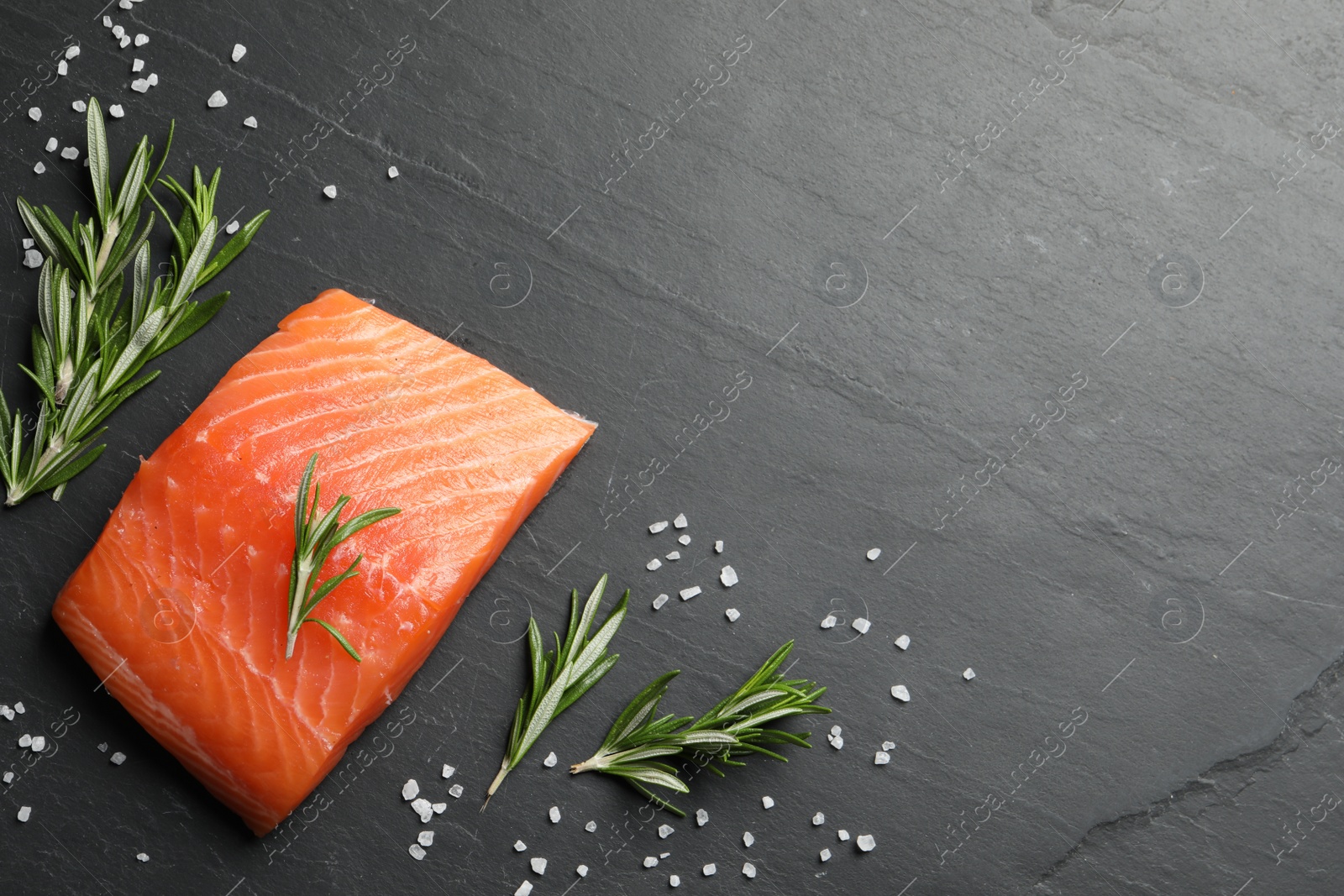 Photo of Fresh raw salmon and ingredients for marinade on black table, flat lay. Space for text