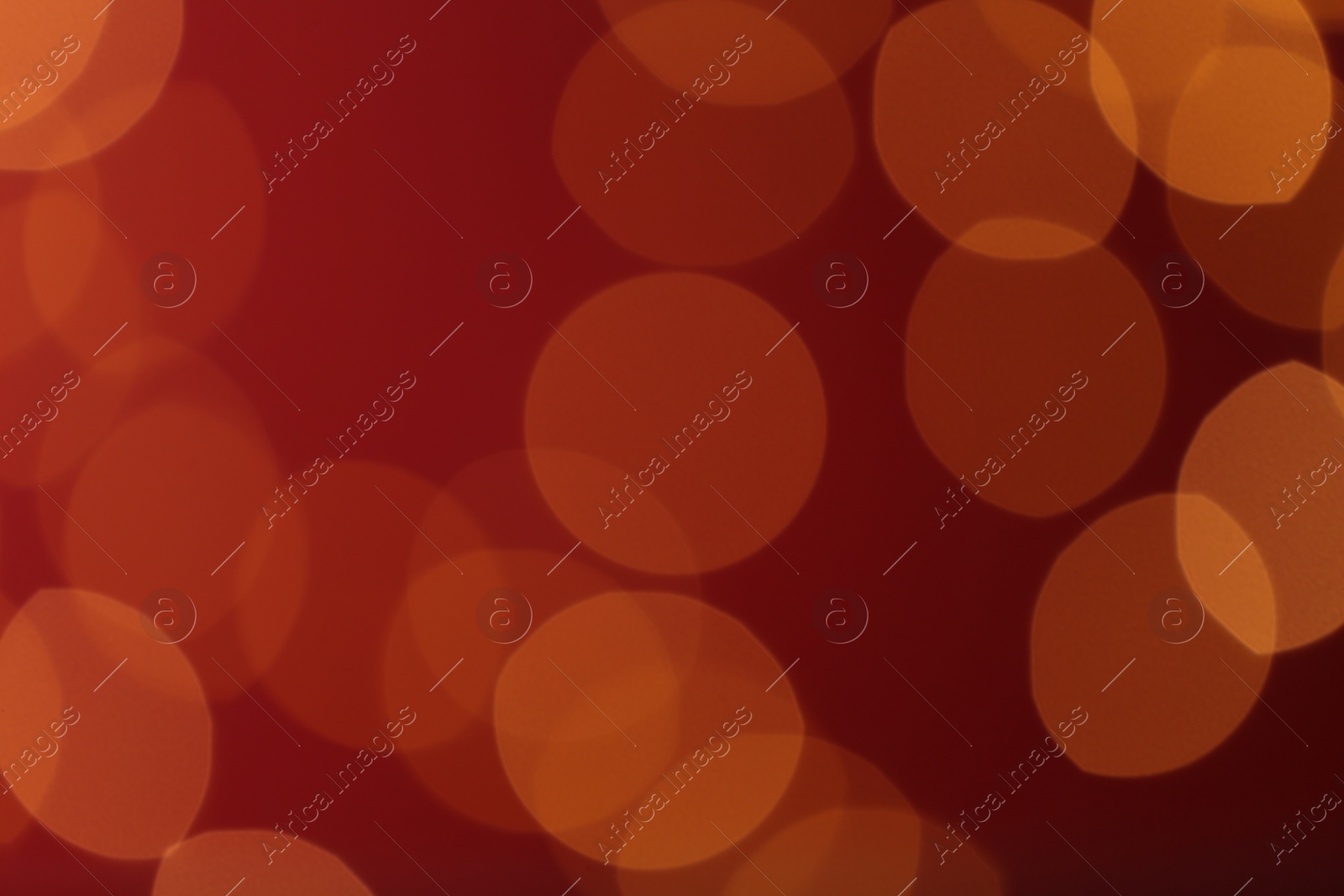 Photo of Blurred view of festive lights on red background. Bokeh effect