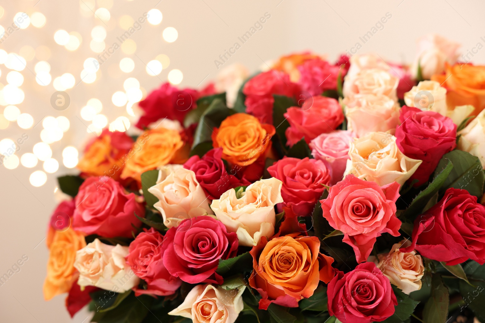 Photo of Beautiful bouquet of colorful roses on beige background, closeup