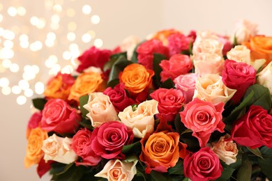 Beautiful bouquet of colorful roses on beige background, closeup