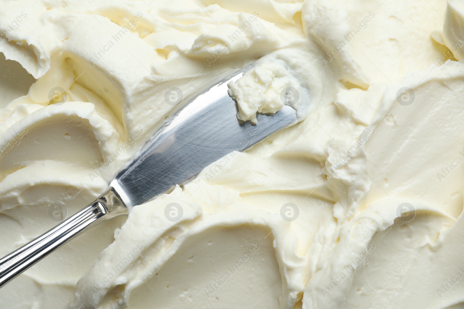 Photo of Tasty cream cheese and knife, closeup view