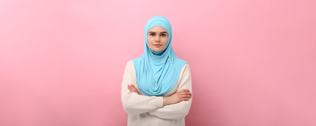 Portrait of Muslim woman in hijab on pink background. Banner design