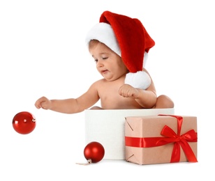 Cute little baby wearing Santa hat sitting in box with Christmas gift on white background