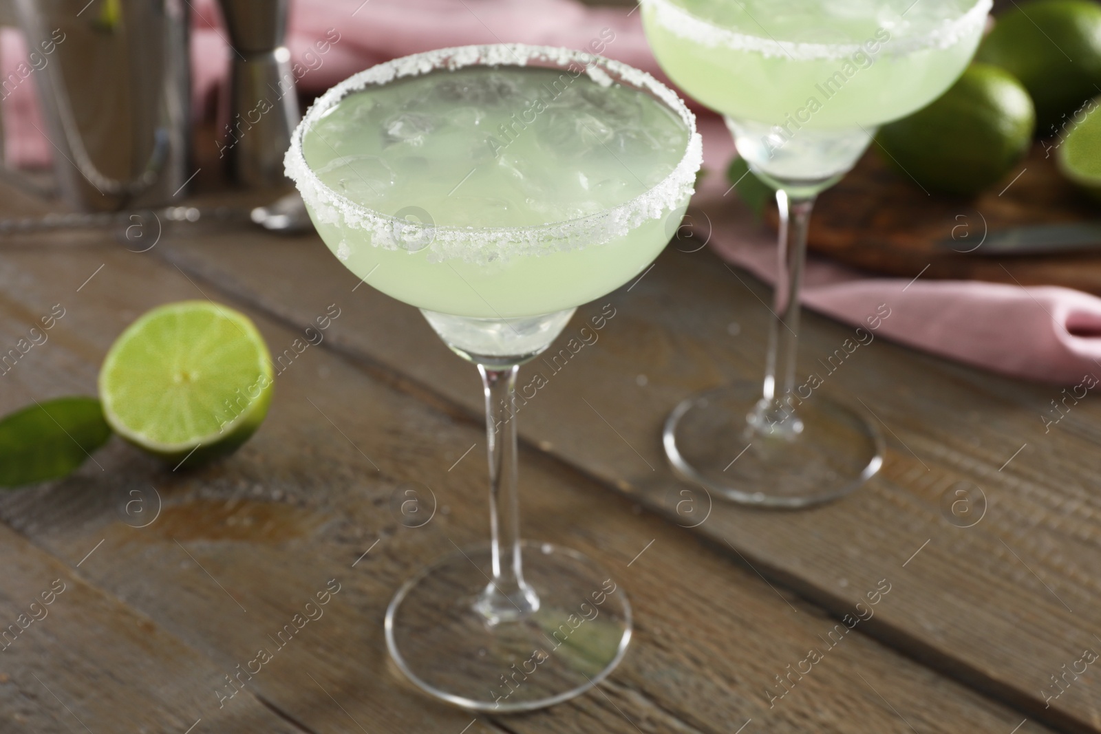 Photo of Delicious Margarita cocktail in glasses on wooden table, closeup