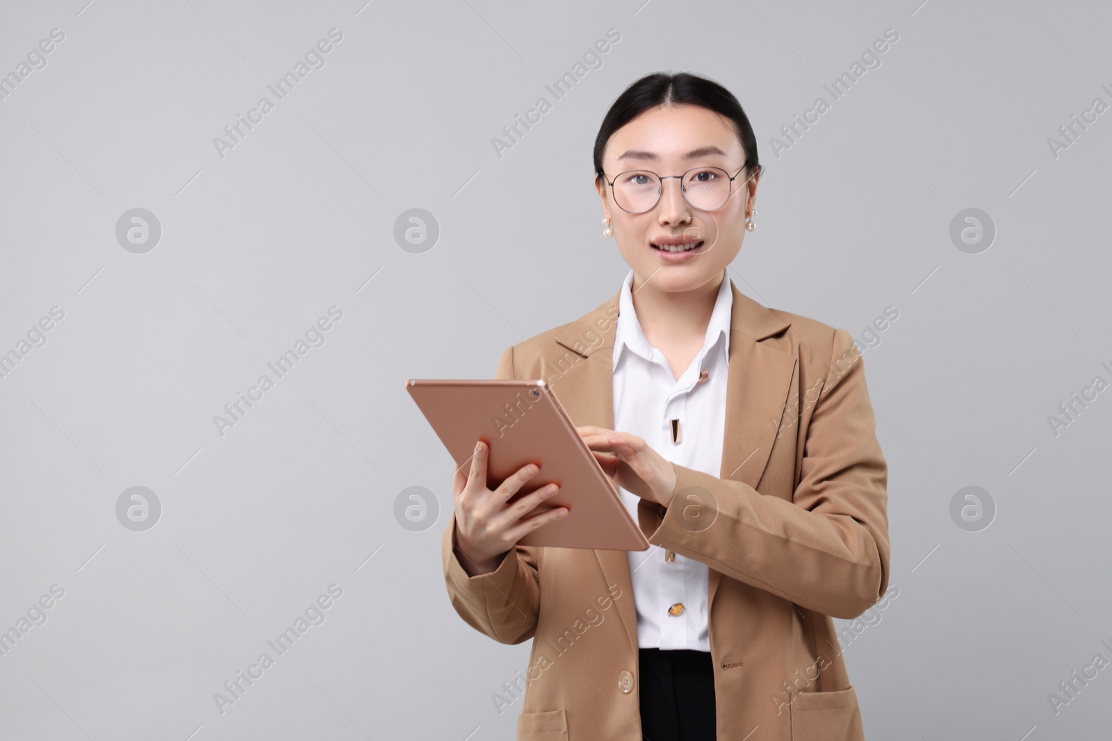 Photo of Portrait of beautiful businesswoman with tablet on grey background. Space for text