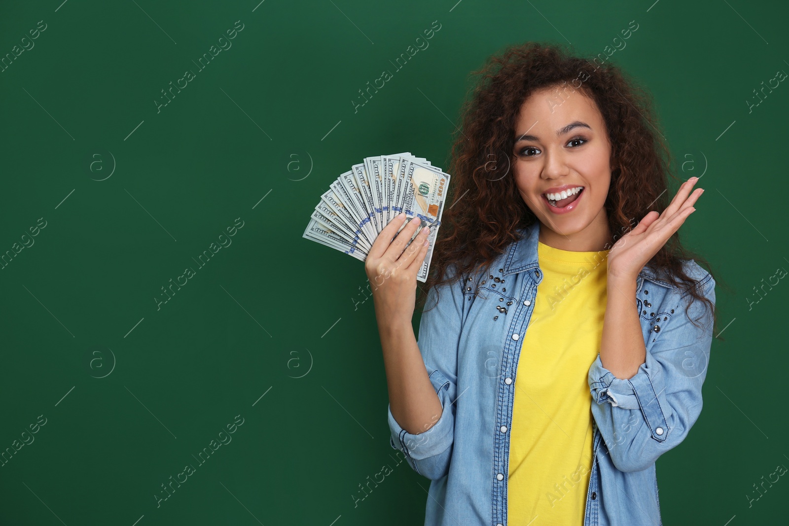 Photo of Young African-American woman with money on color background. Space for text