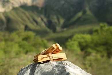 Photo of Many palo santo sticks on stone surface in high mountains