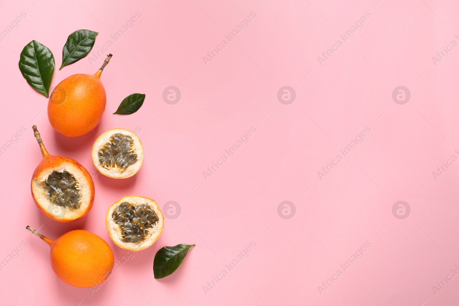 Photo of Delicious ripe granadillas on pink background, flat lay. Space for text