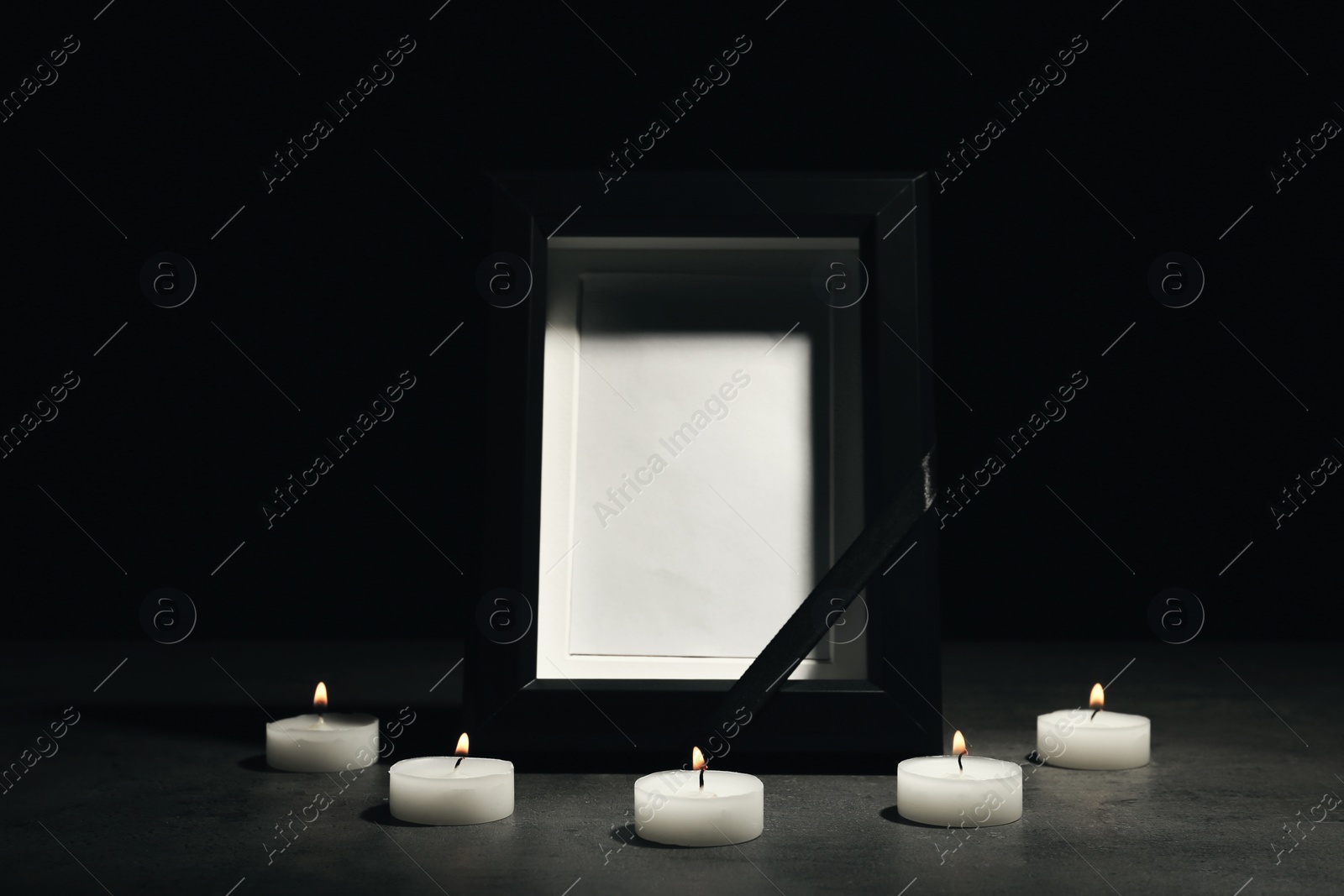 Photo of Funeral photo frame and burning candles on dark background