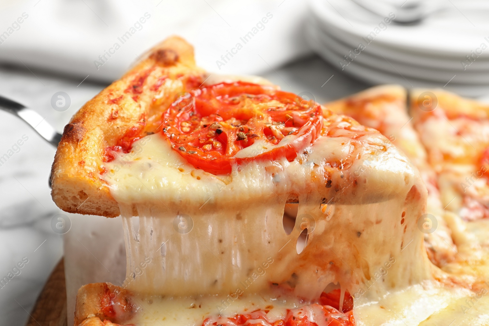 Photo of Taking slice of hot cheese pizza Margherita on table, closeup