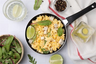 Photo of Delicious scrambled eggs with tofu and ingredients on white table, flat lay