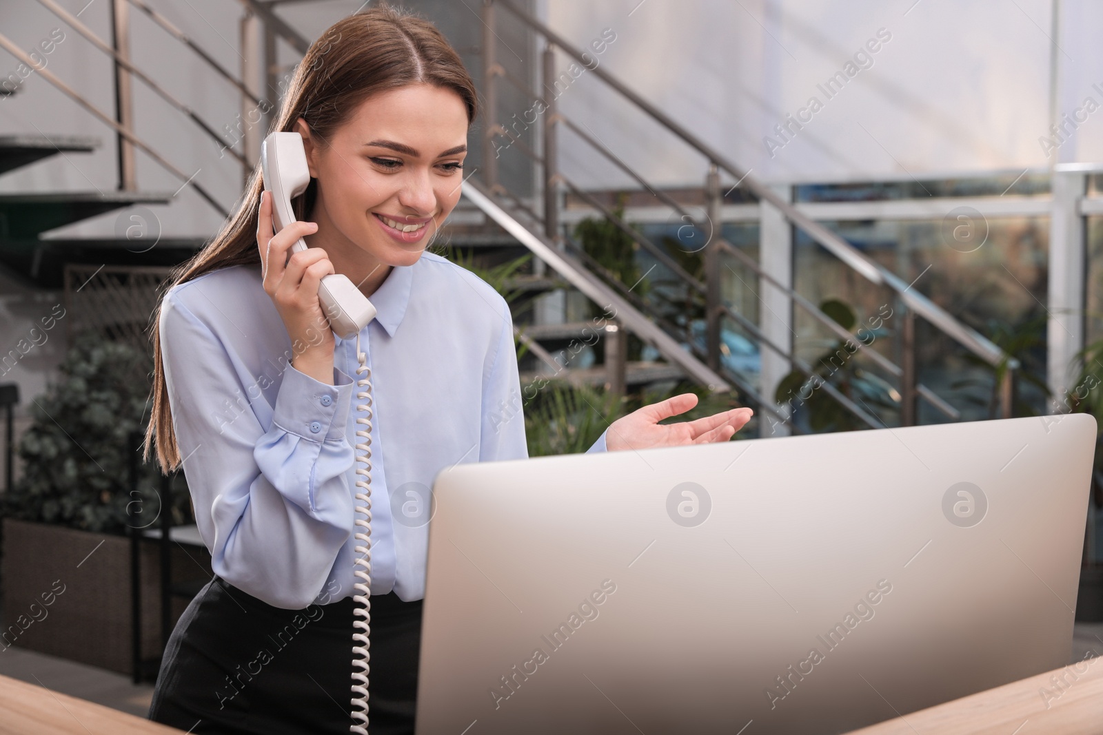 Photo of Female receptionist talking on phone at workplace