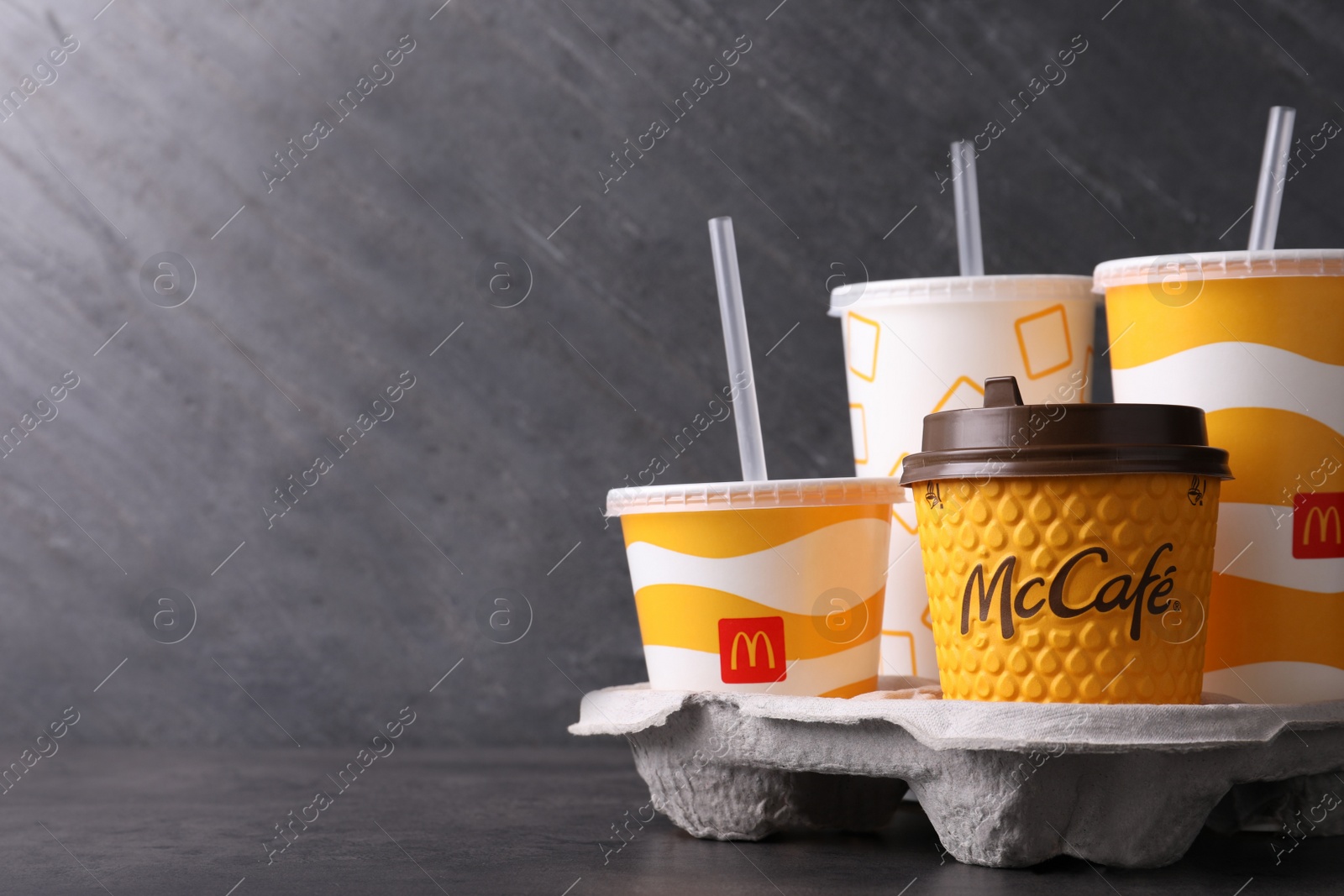 Photo of MYKOLAIV, UKRAINE - AUGUST 12, 2021: Cold and hot McDonald's drinks on grey table. Space for text