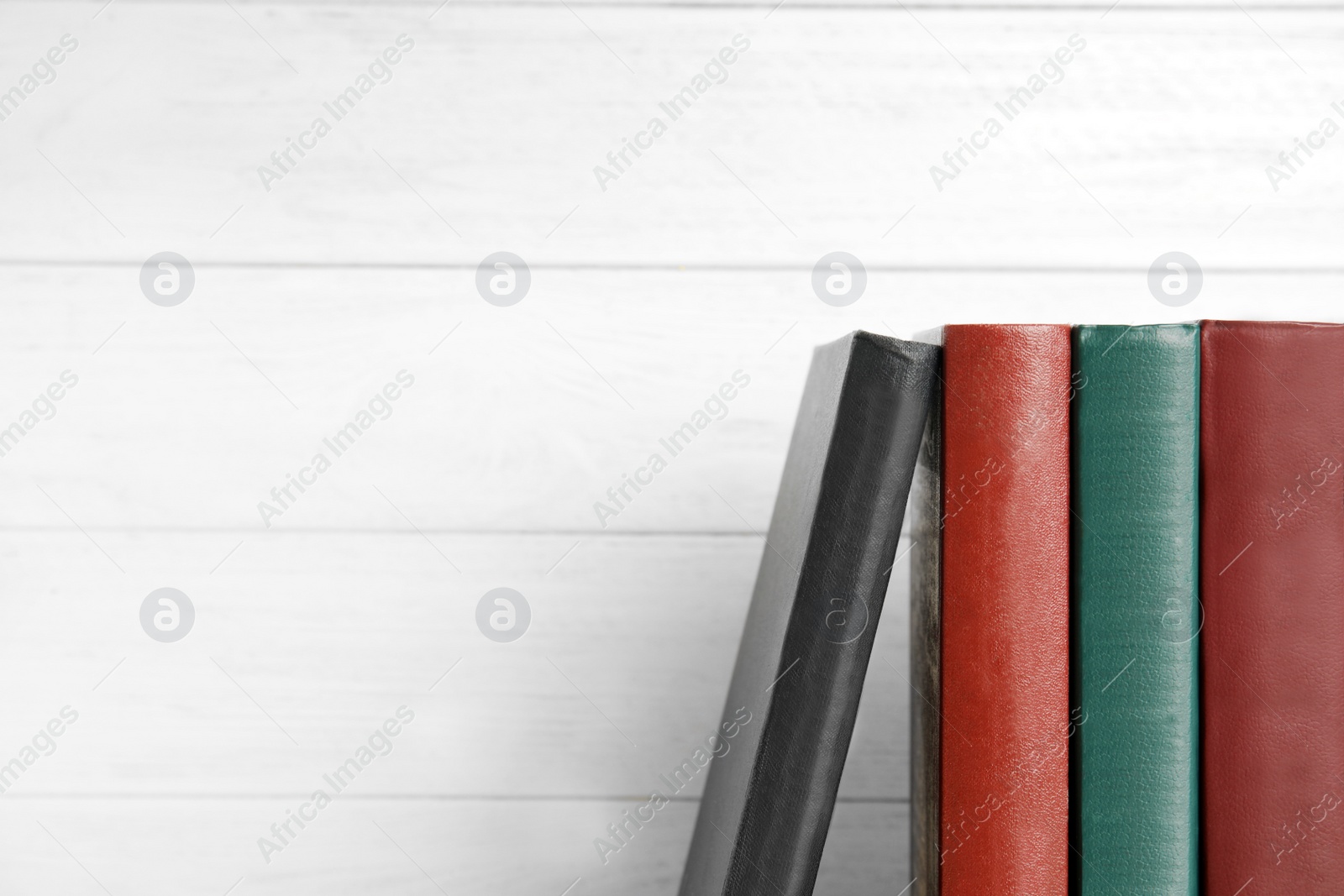 Photo of Collection of old books on white wooden background, space for text