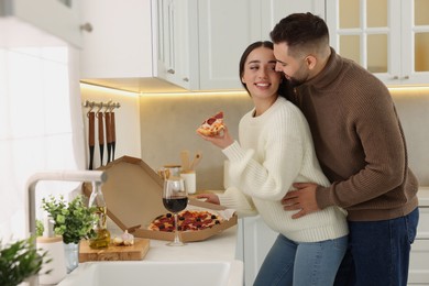 Photo of Affectionate young couple spending time together in kitchen. Space for text