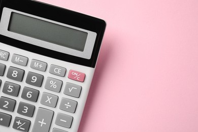 Calculator on pink background, top view. Space for text