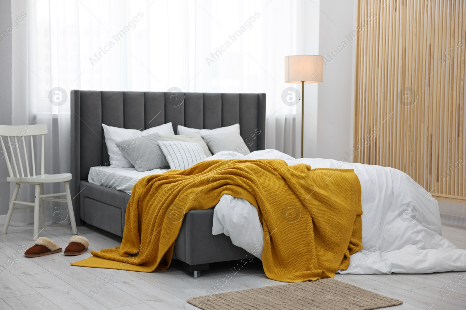 Photo of Bright plaid on bed in stylish bedroom