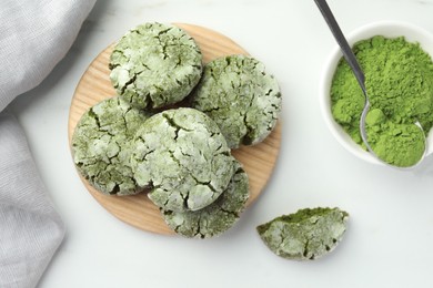 Board with tasty matcha cookies and powder on white table, flat lay