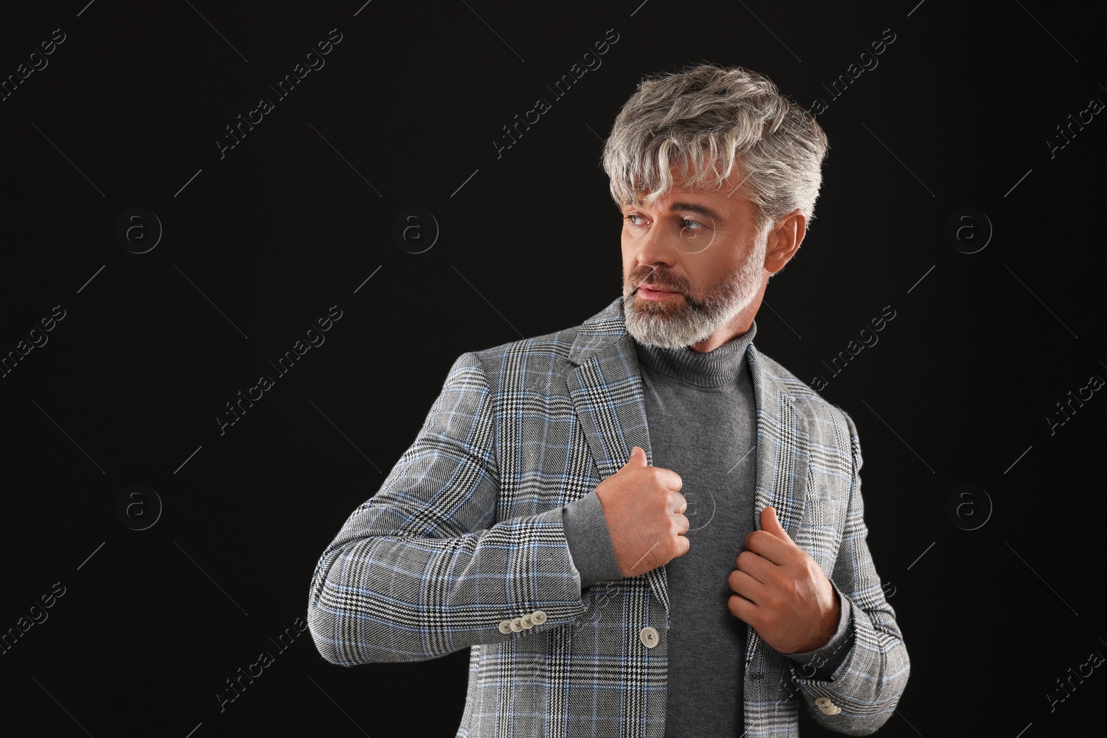 Photo of Portrait of confident man with beautiful hairstyle on black background. Space for text