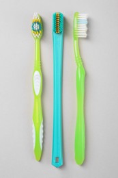 Many different toothbrushes on light background, flat lay