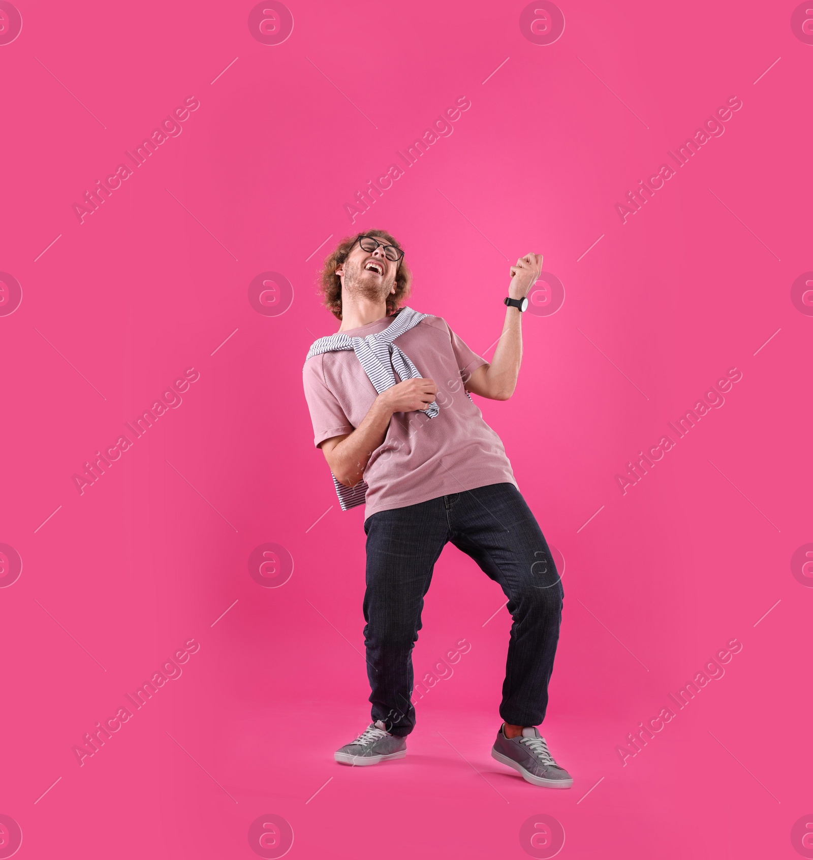 Photo of Young man playing air guitar on color background