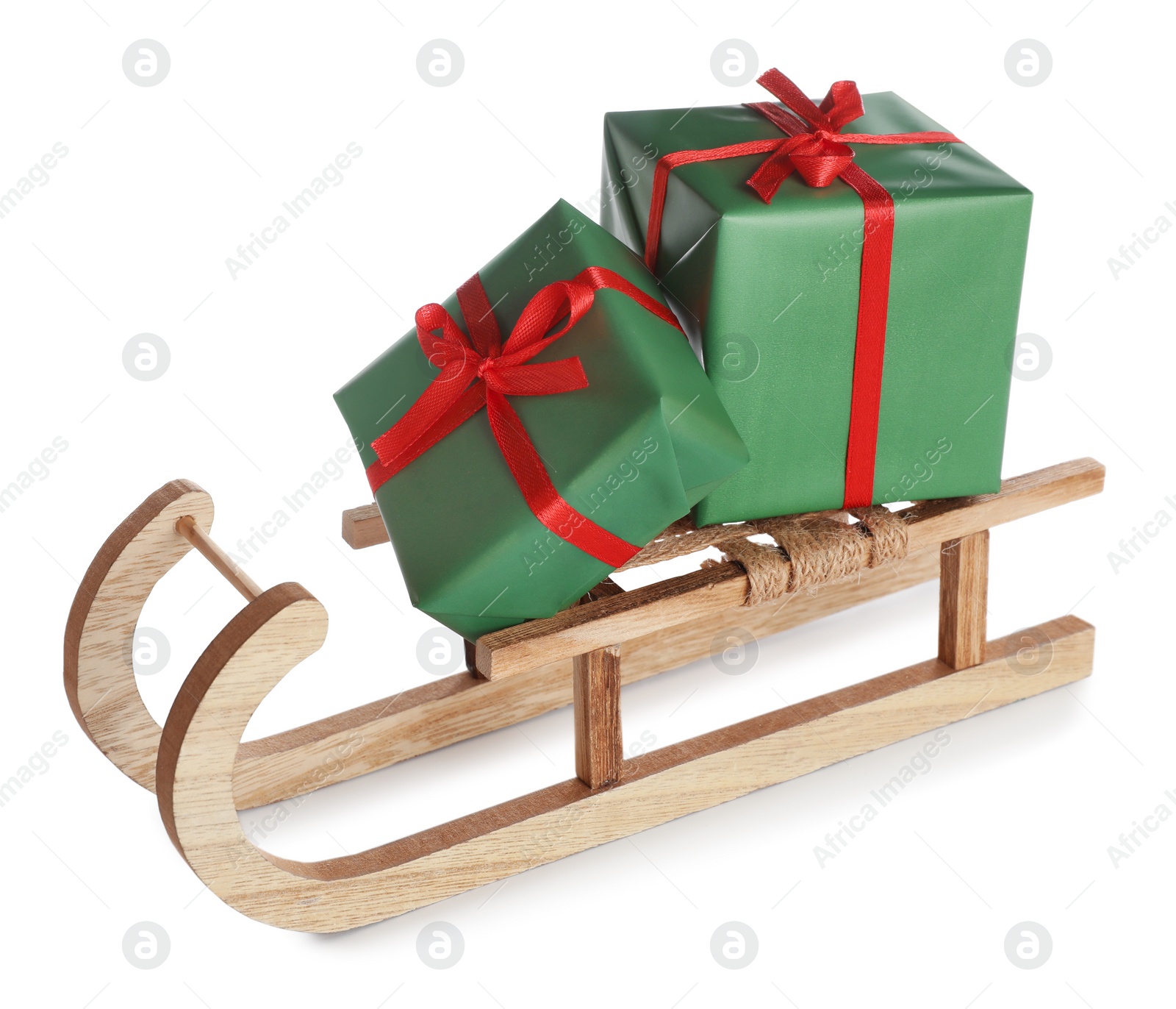 Photo of Wooden sleigh with Christmas gift boxes on white background