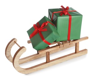 Photo of Wooden sleigh with Christmas gift boxes on white background