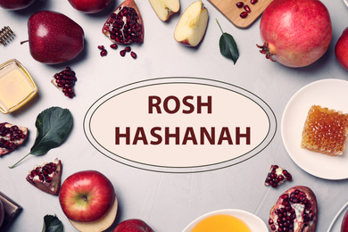 Image of Frame of honey, apples and pomegranates on light table, flat lay. Rosh Hashanah holiday