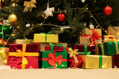 Many different gift boxes on floor near Christmas tree